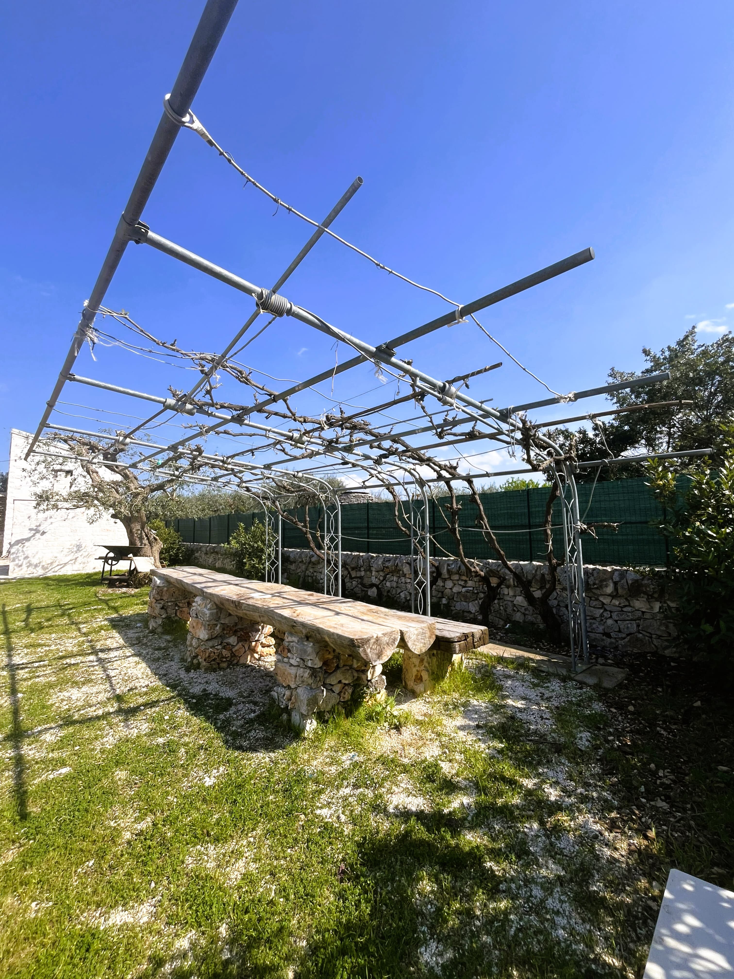 Pergola esterna con panca in pietra